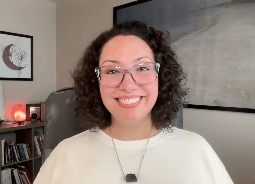 Photo of woman wearing glasses smiling at the camera.